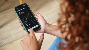 GettyImages-2170383436-árfolyam-befektetés-digitális-mobilalkalmazás-okostelefon-pénzügy-részvény-technológia-tőzsde